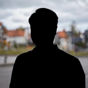 Silhouette på en anonym person, i bakgrunden syns hus