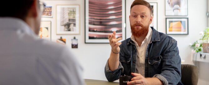 Tobias sitter i en diskussion. I förgrunden syns Martin.